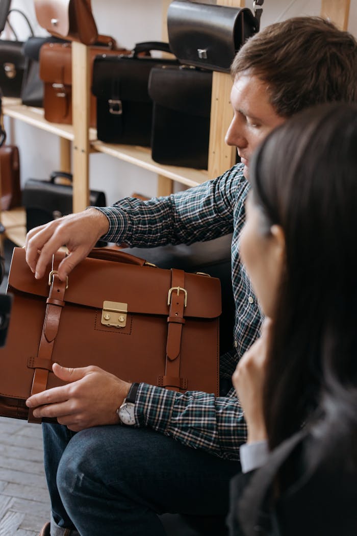 Man In Black And White Long Sleeve Shirt Holding Brown Leather Bag 6649411